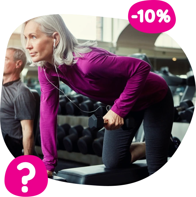 Kobieta w średnim wieku z siwymi włosami ubrana w fioletowy top sportowy i czarne legginsy wykonująca wiosłowanie z hantlami na siłowni, ze słuchawkami w uszach, z różowymi znaczkami rabatowymi pokazującymi „-10%” i znak zapytania.